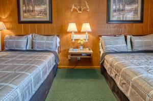 a hotel room with two beds and a side table at Sabinal Inn in Sabinal