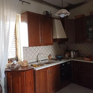 a kitchen with wooden cabinets and a sink and a window at 80 m² Vista Mare in Policastro Bussentino