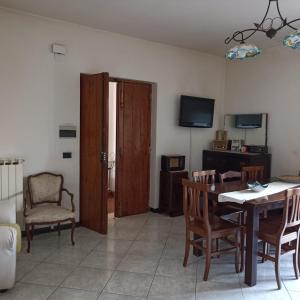 a living room with a table and chairs and a television at 80 m² Vista Mare in Policastro Bussentino