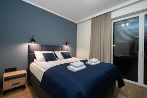 a bedroom with a large bed with towels on it at Sunkrab in Ustronie Morskie