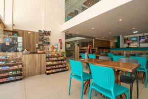 馬塞約的住宿－Acqua Inn Maceió Ponta Verde，餐厅设有蓝色的椅子和木桌