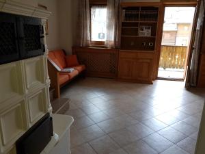 een woonkamer met een oranje bank en een vloer bij Chalet Rasia in Livigno