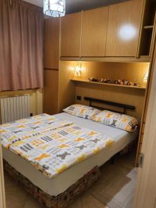 een slaapkamer met een bed met een quilt bij Chalet Rasia in Livigno
