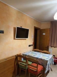 een kamer met een tafel en stoelen en een tv aan de muur bij Chalet Rasia in Livigno