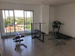 un gimnasio con 2 bicicletas estáticas y una gran ventana en Departamento loft con estacionamiento, en Asunción