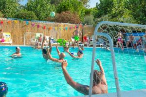 a group of people playing in a swimming pool at JuliaMare Village in Giulianova