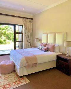 - une chambre avec un grand lit et une grande fenêtre dans l'établissement Amazing 4 bedrooms house with backup power in Zimbali Ballito Durban, à Ballito