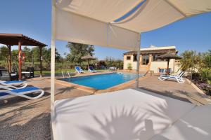 Finca Calderitx 253 by Mallorca Charme في أرياني: سرير المظلة البيضاء أمام حمام السباحة