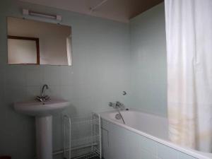 y baño blanco con lavabo y bañera. en LE PETIT FROUAS CENTRE en Vielle-Saint-Girons