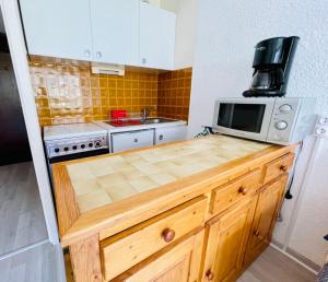 a kitchen with a counter with a microwave on it at Nice 28m Comfort In The Heart La Salle Les Alpes in La Salle Les Alpes