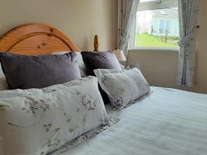 una camera da letto con letto, cuscini e finestra di Abhainn Ri Cottages a Blessington