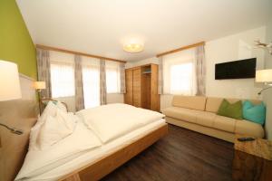 1 dormitorio con 1 cama grande y 1 sofá en Appartement Kristall en Schladming