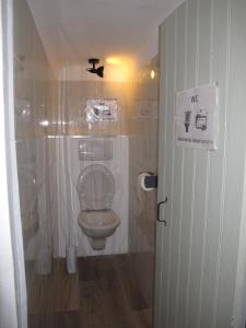 - une salle de bains avec toilettes et un panneau sur la porte dans l'établissement Appartement T1 bis cosy avec patio 17 BIS, à Tourbes