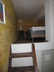 ein kleines Zimmer mit einem Bett und einem Stuhl in der Unterkunft Appartement T1 bis cosy avec patio 17 BIS in Tourbes