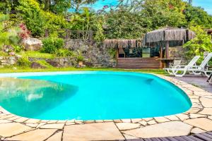 een zwembad in een tuin met een patio bij Cantinho Alentejano in Ilhabela