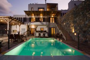 a villa with a swimming pool in front of a house at Elounda Solfez Villas in Elounda