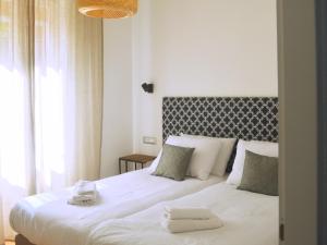 a bedroom with a large white bed with towels on it at Apartment Céleste - Directly on the Beach in Mošćenička Draga