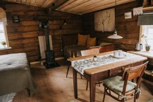 a room with a table and a bed in a cabin at Vienkiemio Oazė - Namelis Prie Šermukšnio in Galvokai