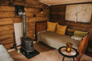 a bedroom with a bed and a wood stove at Vienkiemio Oazė - Namelis Prie Šermukšnio in Galvokai