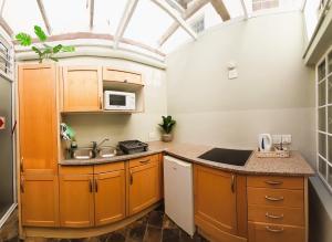 a kitchen with orange cabinets and a glass ceiling at The Greenhouse Guesthouse in Cape Town