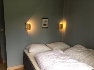un letto in una camera con due lampade a muro di Flat in Trysil Ski in ski out and sauna a Trysil