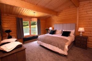 a bedroom with a large bed and a window at Cambridgeshire Lakes - luxury lodges in a stunning lake location in Gamlingay