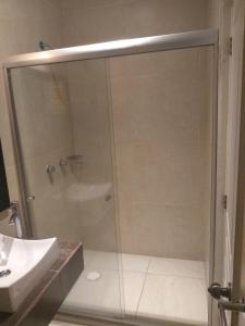 una ducha con una puerta de cristal junto a un lavabo en Hotel Anber, en Dolores Hidalgo