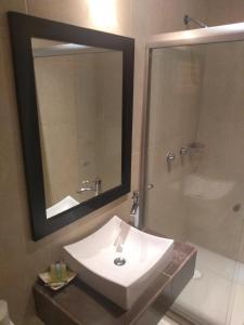a bathroom with a sink and a shower with a mirror at Hotel Anber in Dolores Hidalgo