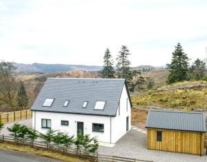 a white house with solar panels on its roof at Blackmount House in Oban