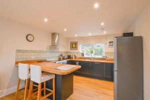 a kitchen with a wooden counter top and a refrigerator at Blackmount House in Oban +22 photos