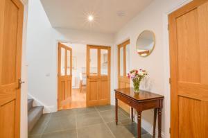 a hallway with a table and a vase of flowers on it at Blackmount House in Oban