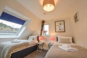 a bedroom with two beds and a window at Blackmount House in Oban