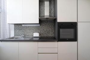 een witte keuken met een spoelbak en een magnetron bij Palazzine apartments in Pula +23 foto's