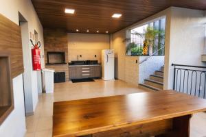 a kitchen with a wooden table in a room at TuCasa Flats - Viva uma experiência de morador! in Foz do Iguaçu