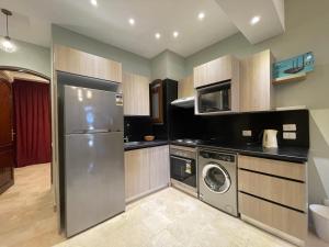 uma cozinha com um frigorífico de aço inoxidável e uma máquina de lavar louça em El Gouna 1 Bedroom Apartment west golf ground floor em Hurghada