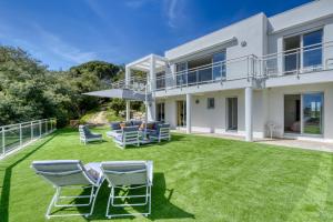 une image d'une maison avec une pelouse dans l'établissement Beautiful contemporary villa with sea view, heated swimming pool, near Saint Tropez, à Cavalaire-sur-Mer