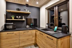 a kitchen with a sink and a microwave at Domki i tyle in Rabka