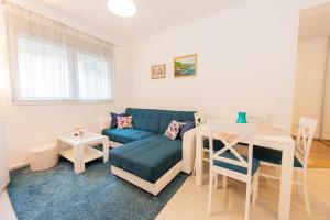 a living room with a blue couch and a table at Apartment Peace in Kotor