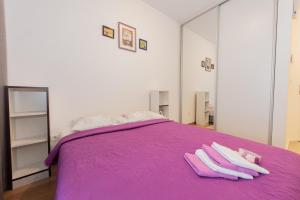 a bedroom with a purple bed with two towels on it at Apartment Peace in Kotor