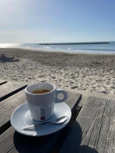 a cup of coffee sitting on a table at the beach at Soleil des Marquises in Frontignan