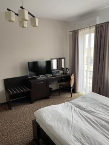 a hotel room with a bed and a desk at Apartamenty Centrum in Olkusz