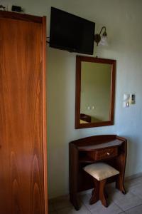 een kamer met een bureau, een spiegel en een stoel bij Tsipos Rooms in Stavros
