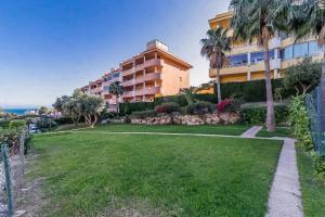 apartamentowiec z trawnikiem i palmami w obiekcie 69-Penthouse Apartment with Views in Torreblanca, Fuengirola w mieście Fuengirola