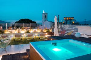 a rooftop patio with a hot tub and chairs and lights at Houses & Rooftop Pompei - Sky in Pompei