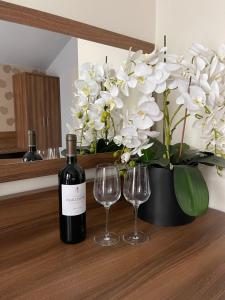 a bottle of wine and two wine glasses on a counter at Apartamenty Centrum in Olkusz