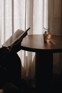 a person is sitting at a table with a laptop at Parkhotel Mondschein, a Member of Design Hotels in Bolzano