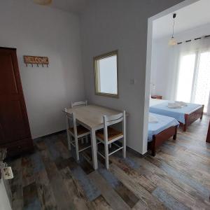 Habitación con mesa, cama, mesa y sillas. en Maria's Hotel, en Palaiochóra