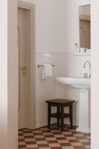 a white bathroom with a sink and a table at Parkhotel Mondschein, a Member of Design Hotels in Bolzano