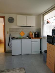 a kitchen with white cabinets and a counter top at Ferienhäuser Steffi und Ruth in Ueckeritz