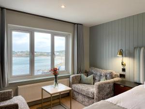 a hotel room with a bed and a couch and a window at The Atlantic in Hugh Town